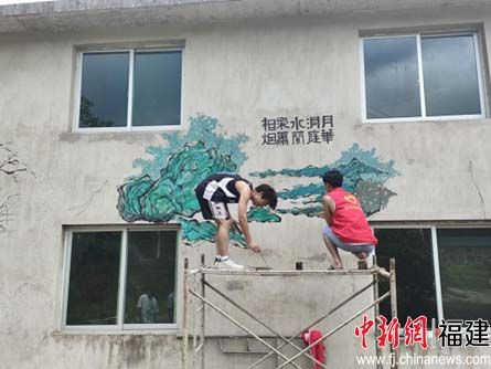 图为实践队员在绘制墙面。 三明学院建筑工程学院供图